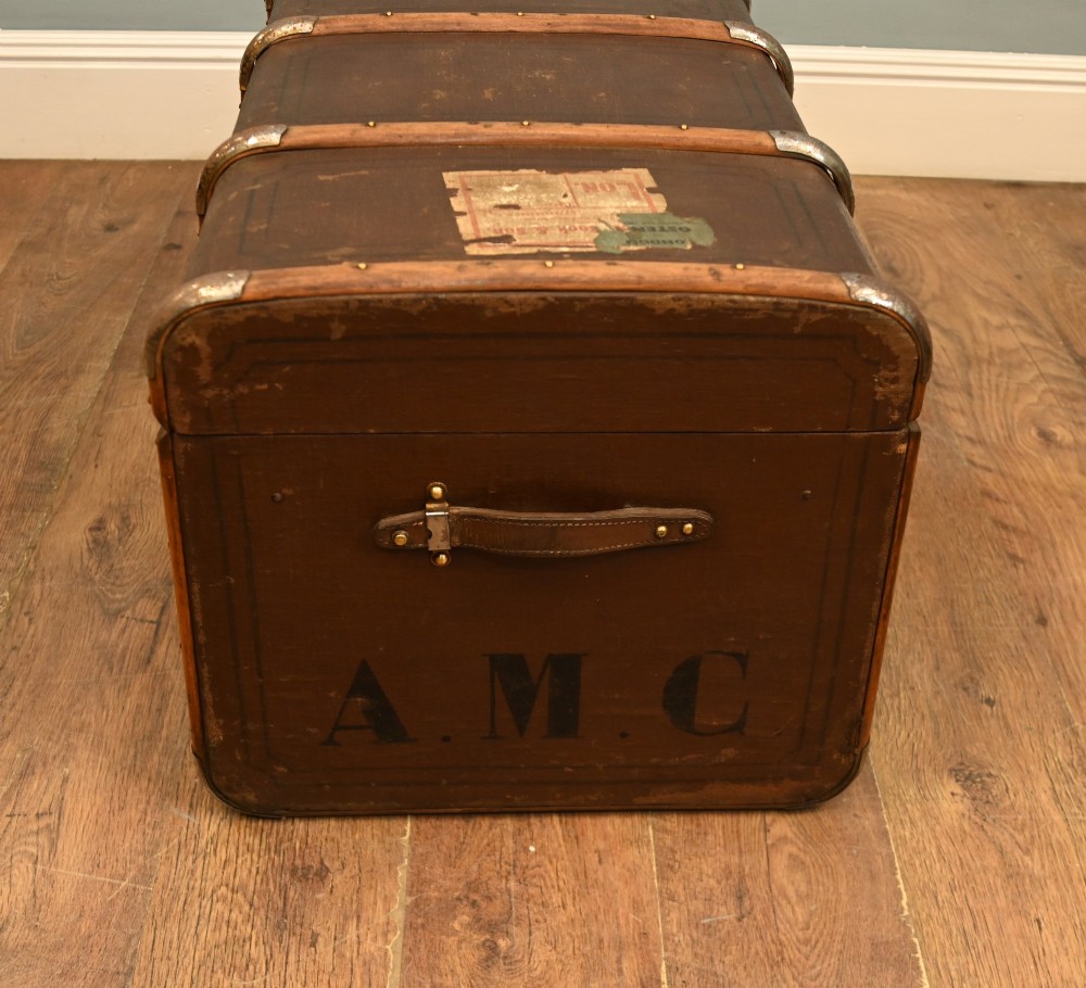 A dark brown 1920s antique steamer trunk with wooden slats, corner brackets, and a central metal latch. View VI