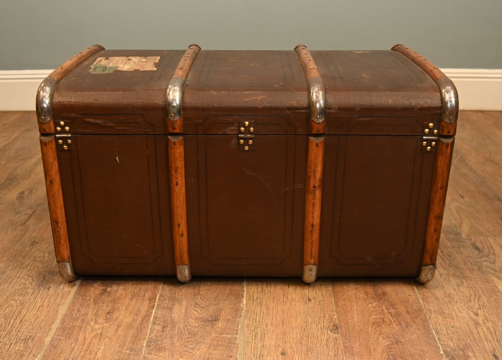 A dark brown 1920s antique steamer trunk with wooden slats, corner brackets, and a central metal latch. View VII