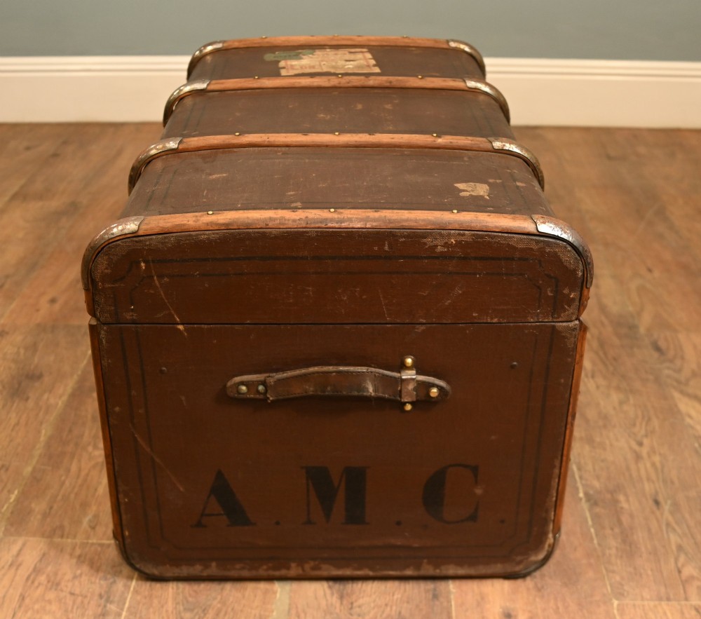 A dark brown 1920s antique steamer trunk with wooden slats, corner brackets, and a central metal latch. View VIII