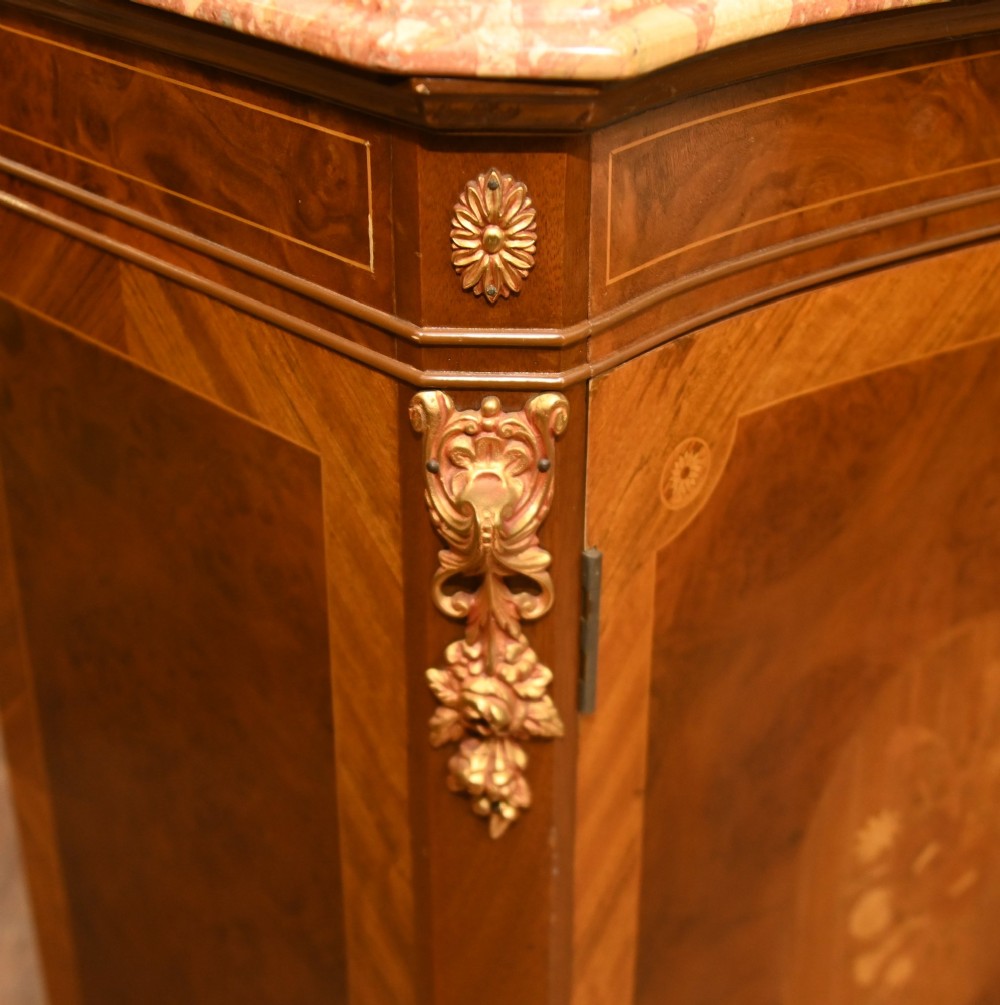A Louis XV Revival walnut side cabinet featuring a serpentine front, floral marquetry inlay, pink marble top, and gilt-bronze mounts on cabriole legs. View VIII