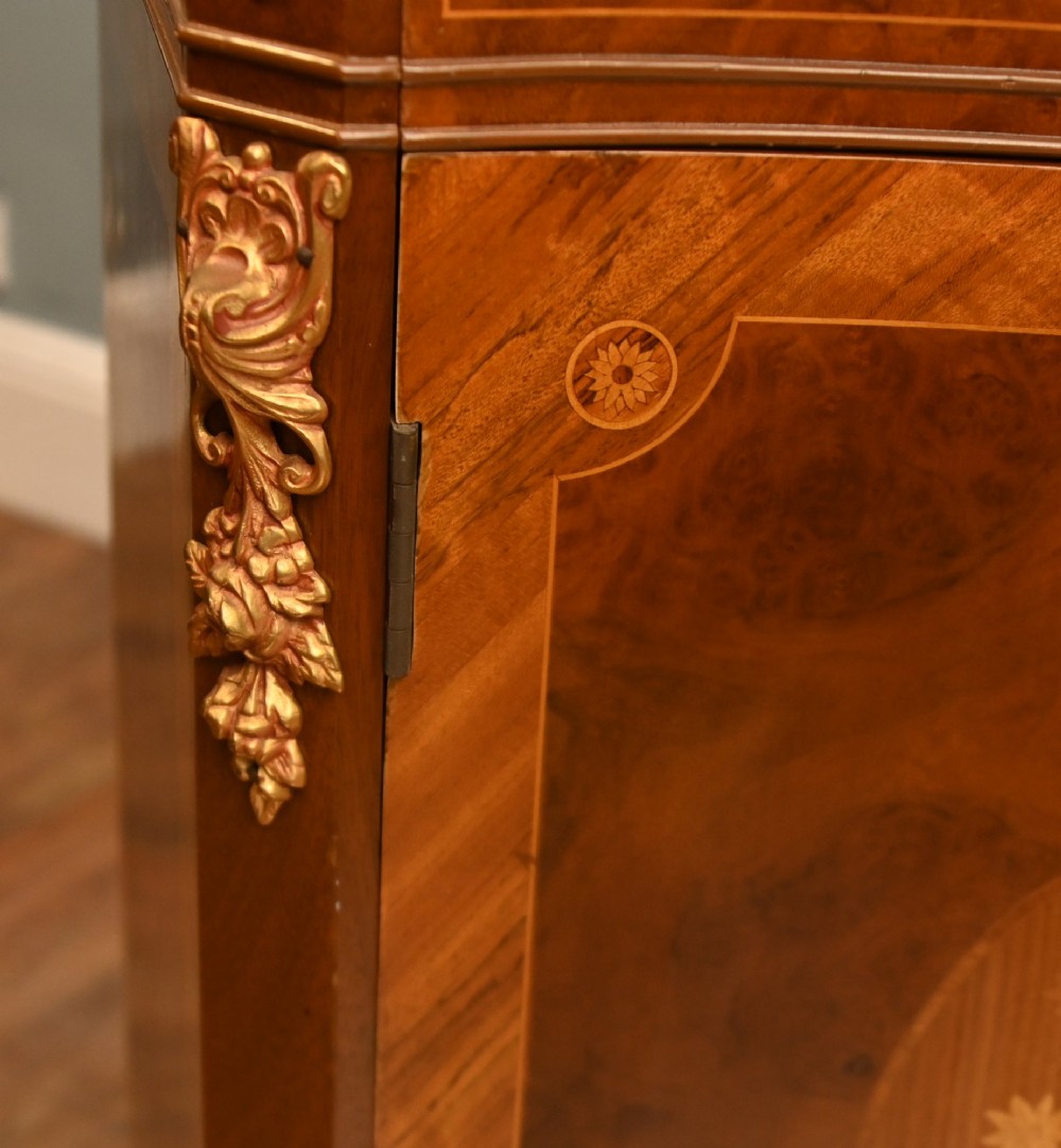 A Louis XV Revival walnut side cabinet featuring a serpentine front, floral marquetry inlay, pink marble top, and gilt-bronze mounts on cabriole legs. View IX