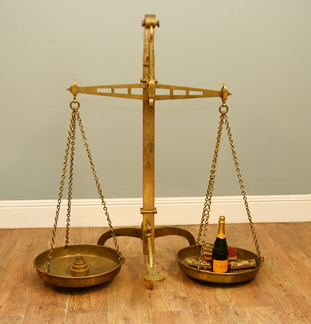 A nineteenth-century brass Avery balance scale featuring a tall central pillar, horizontal beam, twin hanging circular pans, and nested counterweights. View II