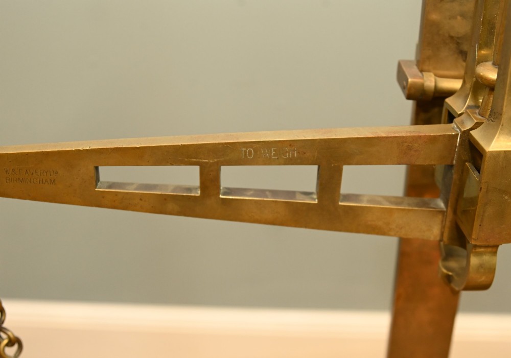 A nineteenth-century brass Avery balance scale featuring a tall central pillar, horizontal beam, twin hanging circular pans, and nested counterweights. View III