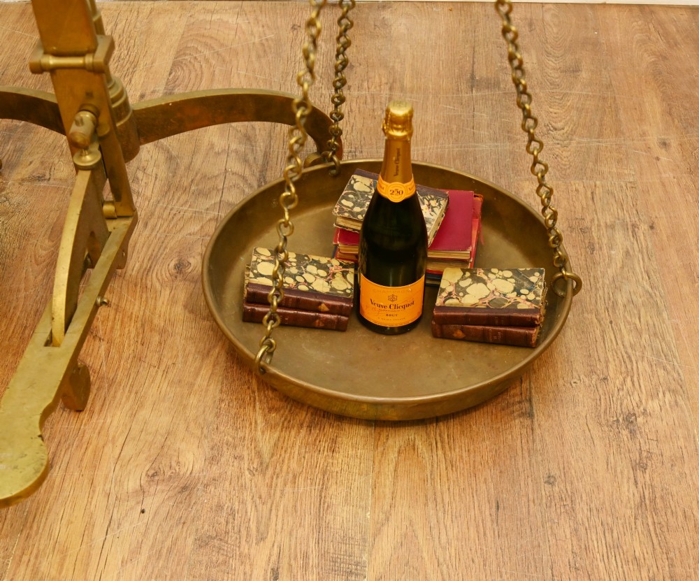 A nineteenth-century brass Avery balance scale featuring a tall central pillar, horizontal beam, twin hanging circular pans, and nested counterweights. View VII