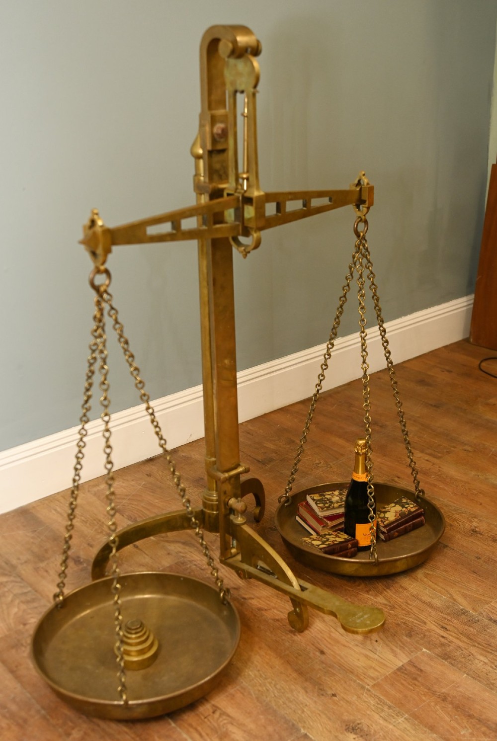 A nineteenth-century brass Avery balance scale featuring a tall central pillar, horizontal beam, twin hanging circular pans, and nested counterweights. View VIII