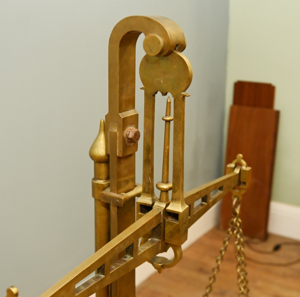 A nineteenth-century brass Avery balance scale featuring a tall central pillar, horizontal beam, twin hanging circular pans, and nested counterweights. View IX