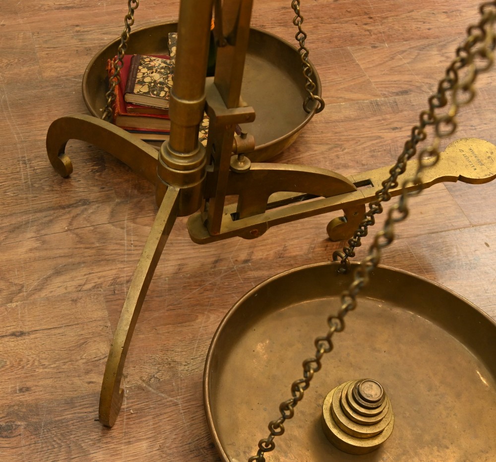 A nineteenth-century brass Avery balance scale featuring a tall central pillar, horizontal beam, twin hanging circular pans, and nested counterweights. View XI
