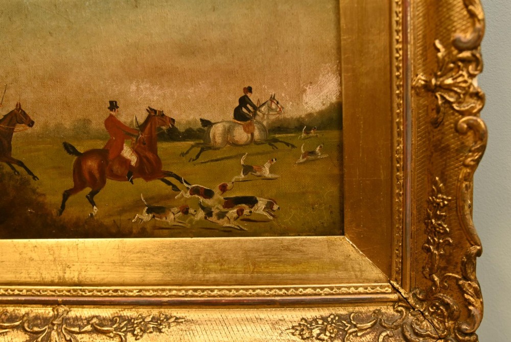 A pair of horizontal antique Victorian oil paintings in ornate gold gilt frames depicting horseback riders and hounds in a field. View V