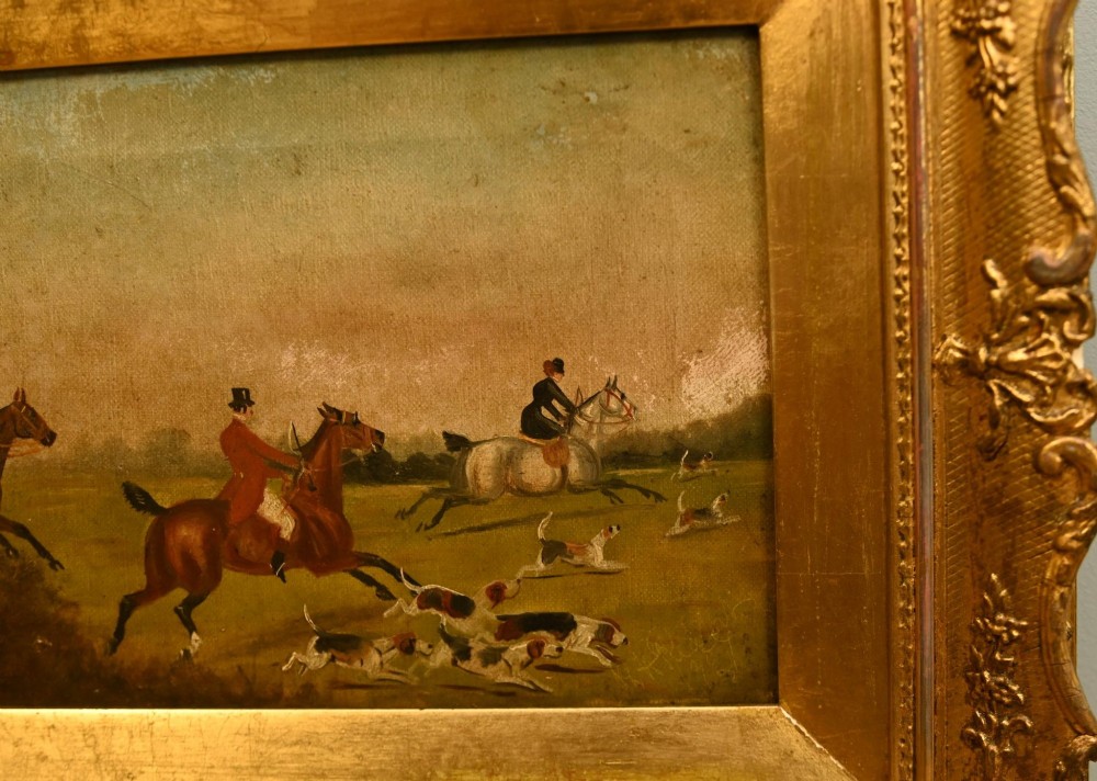A pair of horizontal antique Victorian oil paintings in ornate gold gilt frames depicting horseback riders and hounds in a field. View VI