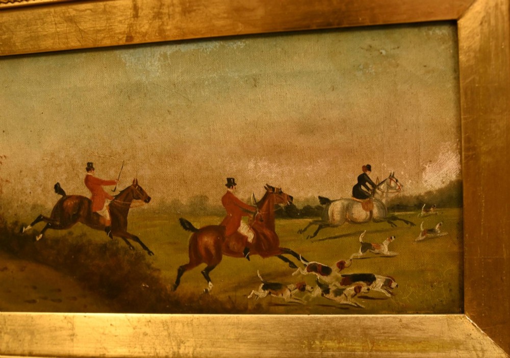 A pair of horizontal antique Victorian oil paintings in ornate gold gilt frames depicting horseback riders and hounds in a field. View VII
