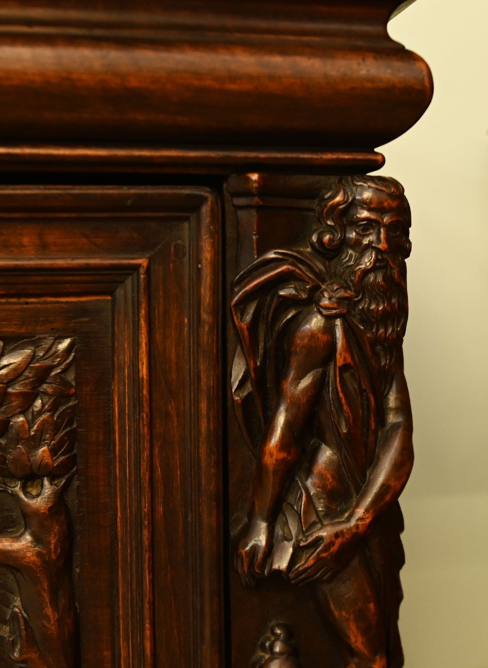 A carved dark walnut coffer featuring a central relief scene flanked by carved corner figures and decorative egg-and-dart base mouldings. View VII