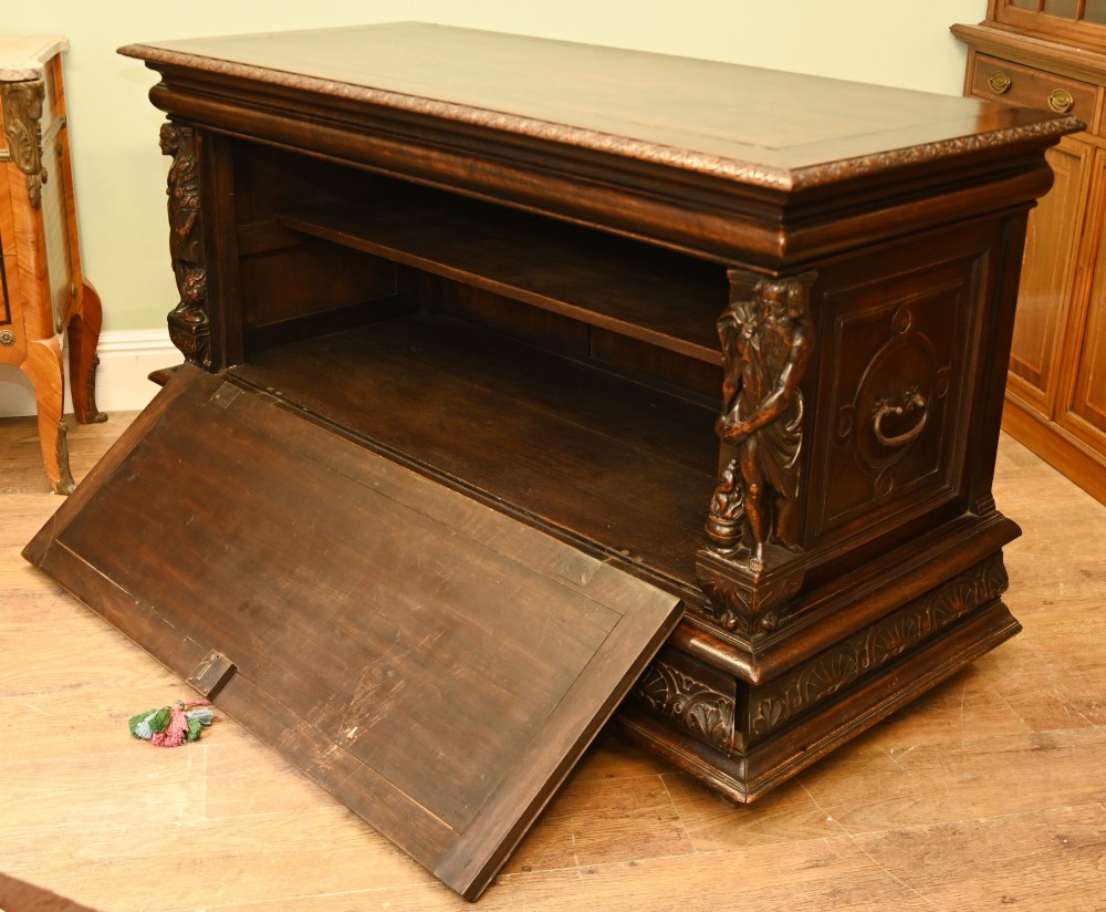 A carved dark walnut coffer featuring a central relief scene flanked by carved corner figures and decorative egg-and-dart base mouldings. View XI
