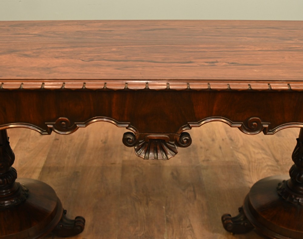 A William IV mahogany library table with a carved apron, shell detail, twin pedestal end supports, and scroll feet. View II