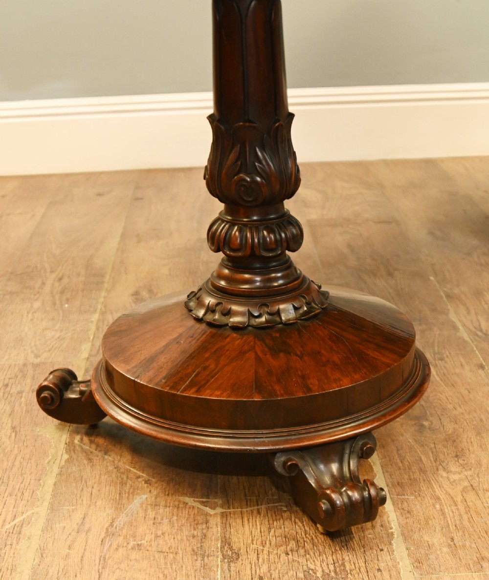 A William IV mahogany library table with a carved apron, shell detail, twin pedestal end supports, and scroll feet. View IV