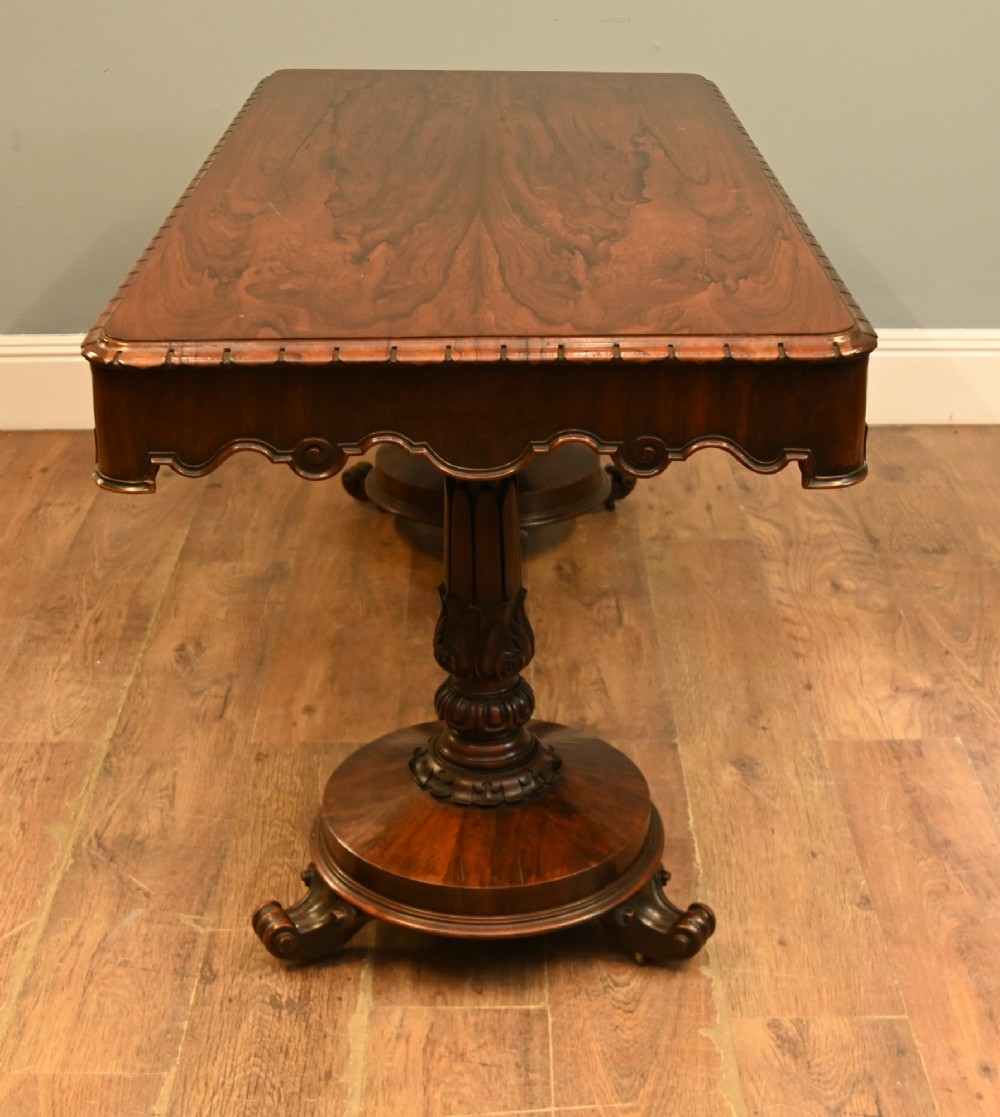 A William IV mahogany library table with a carved apron, shell detail, twin pedestal end supports, and scroll feet. View VI