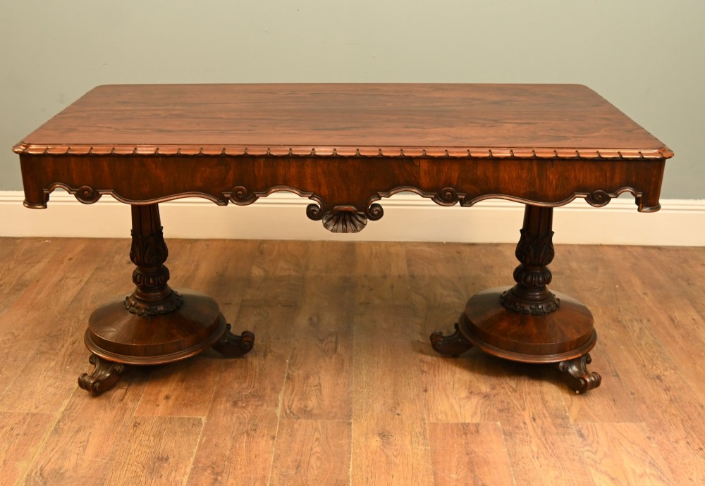 A William IV mahogany library table with a carved apron, shell detail, twin pedestal end supports, and scroll feet. View IX