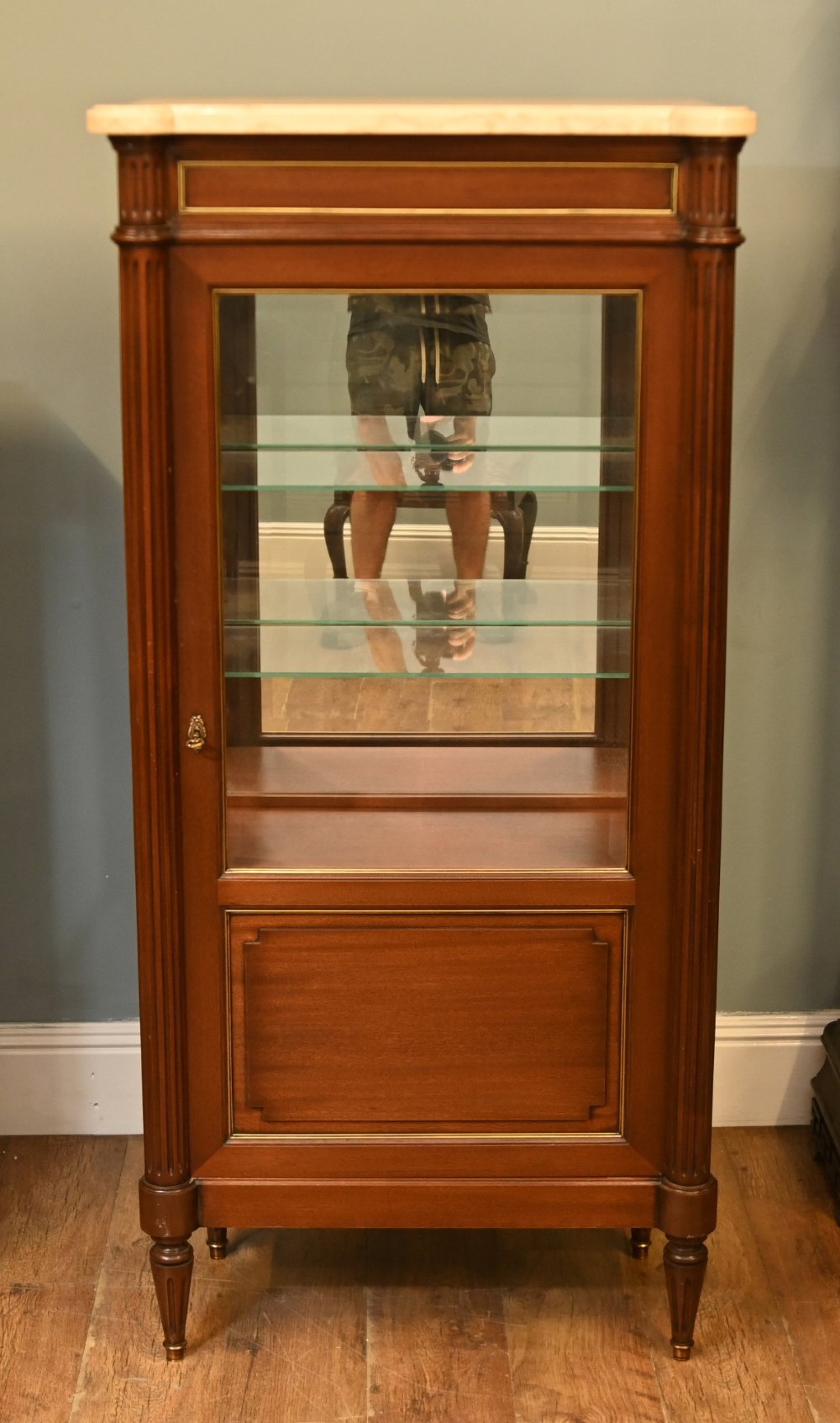A French Directoire style mahogany vitrine cabinet featuring a single glazed door, fluted corner pilasters, brass line inlays, tapered turned feet, and a marble top surface. View II