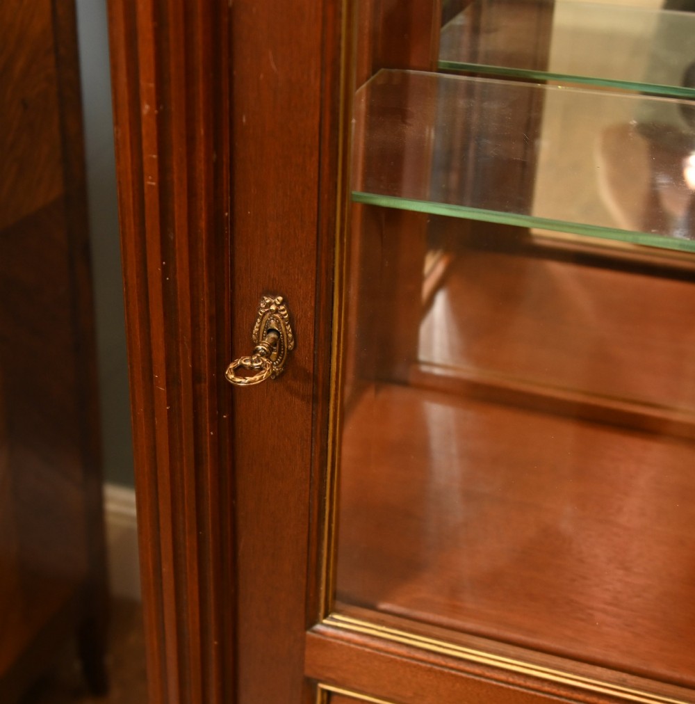 A French Directoire style mahogany vitrine cabinet featuring a single glazed door, fluted corner pilasters, brass line inlays, tapered turned feet, and a marble top surface. View V