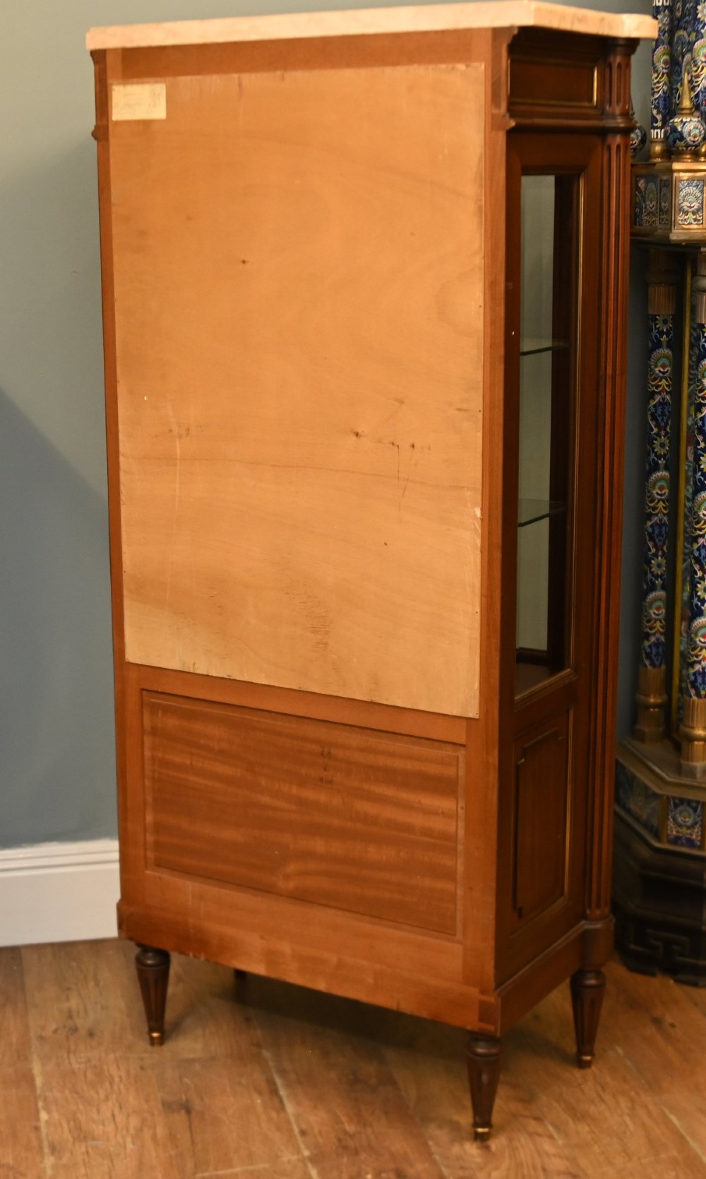 A French Directoire style mahogany vitrine cabinet featuring a single glazed door, fluted corner pilasters, brass line inlays, tapered turned feet, and a marble top surface. View XI
