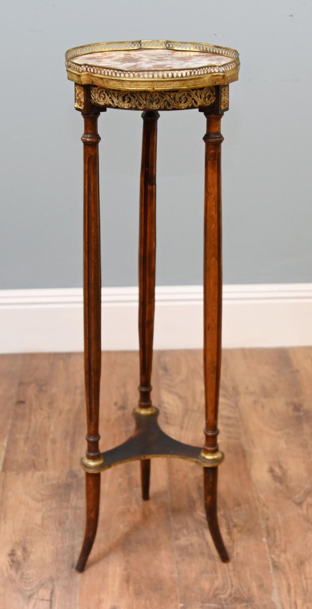 A French Louis XVI style pedestal stand featuring a circular marble top with a pierced brass gallery, supported by three fluted legs and a lower tier. View III