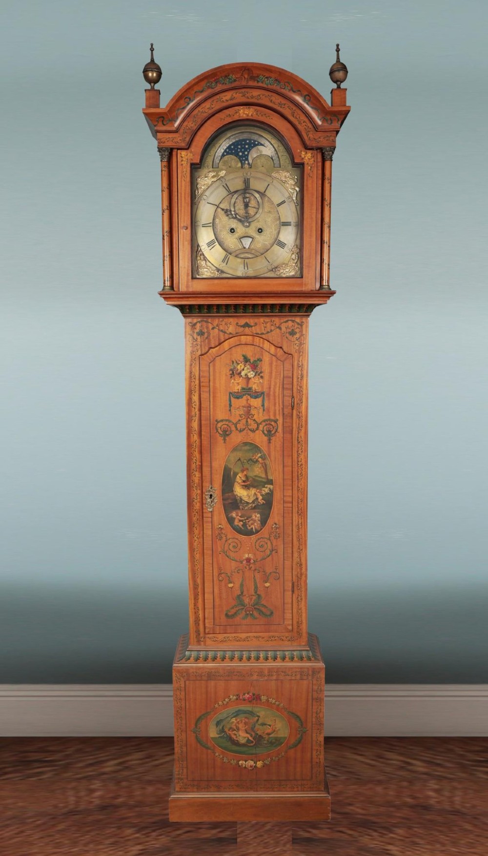 An antique Scottish painted satinwood longcase clock with an arched moonphase dial, brass finials, and neoclassical floral painted panels. View II