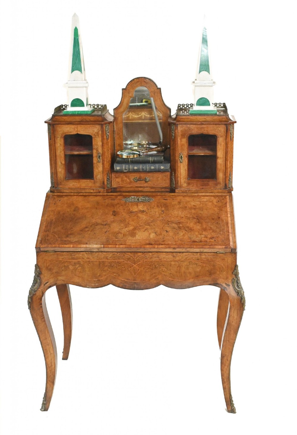 A 19th-century French walnut bonheur du jour desk featuring cabriole legs, a slant-front writing slope, and an upper superstructure with small glazed cabinets framing a central arched mirror.