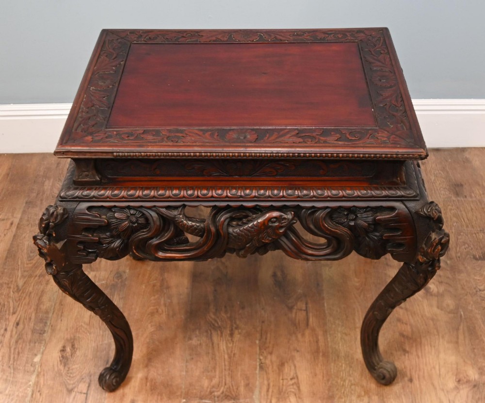 A dark brown antique Japanese side table featuring intricate relief carvings along the apron and cabriole legs. View II