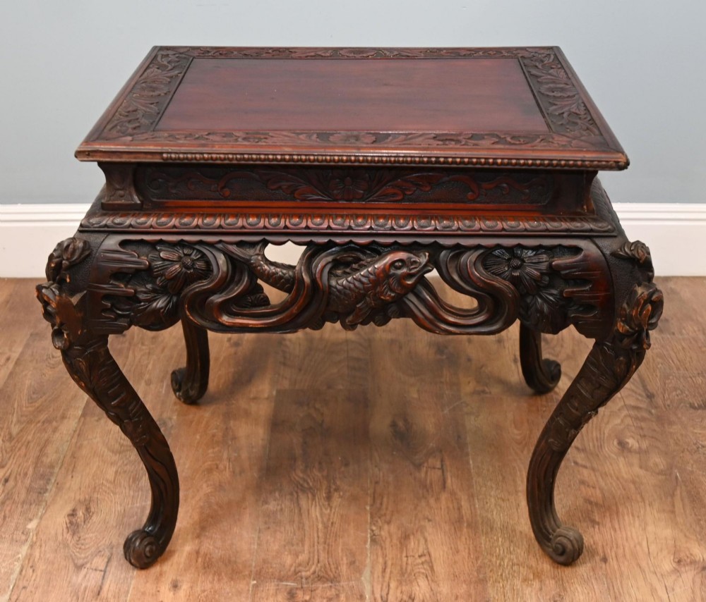 A dark brown antique Japanese side table featuring intricate relief carvings along the apron and cabriole legs. View III