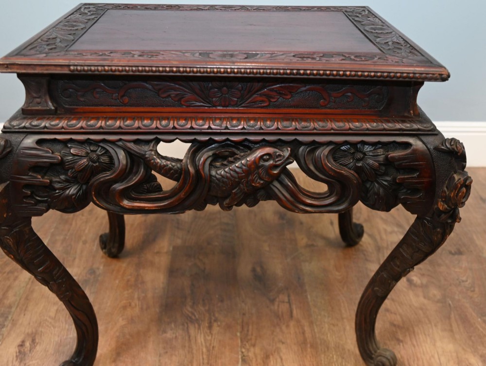 A dark brown antique Japanese side table featuring intricate relief carvings along the apron and cabriole legs. View IV