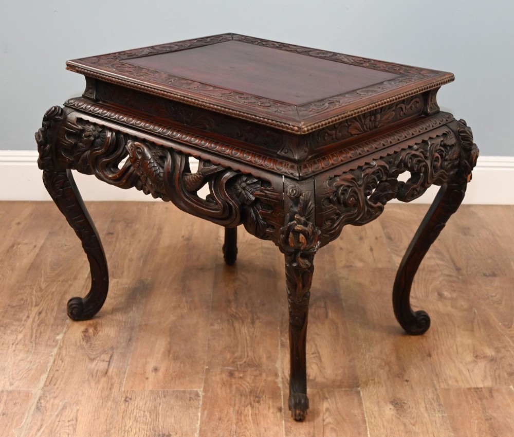 A dark brown antique Japanese side table featuring intricate relief carvings along the apron and cabriole legs. View V