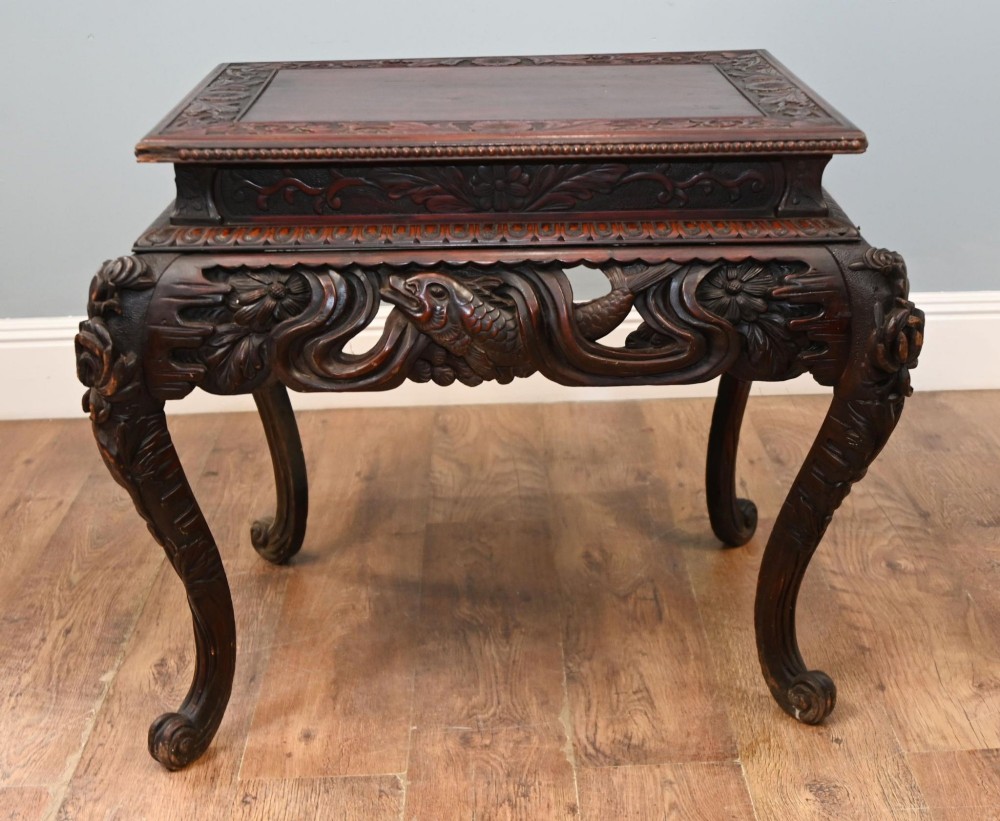 A dark brown antique Japanese side table featuring intricate relief carvings along the apron and cabriole legs. View VI