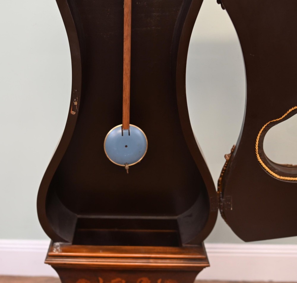 A tall French longcase clock featuring dark brown wood with elaborate floral marquetry inlay, gilt brass mounts, and a circular white enamel dial. View VII