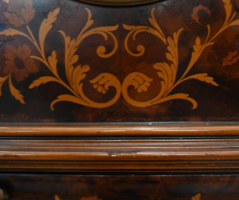 A tall French longcase clock featuring dark brown wood with elaborate floral marquetry inlay, gilt brass mounts, and a circular white enamel dial. View IX