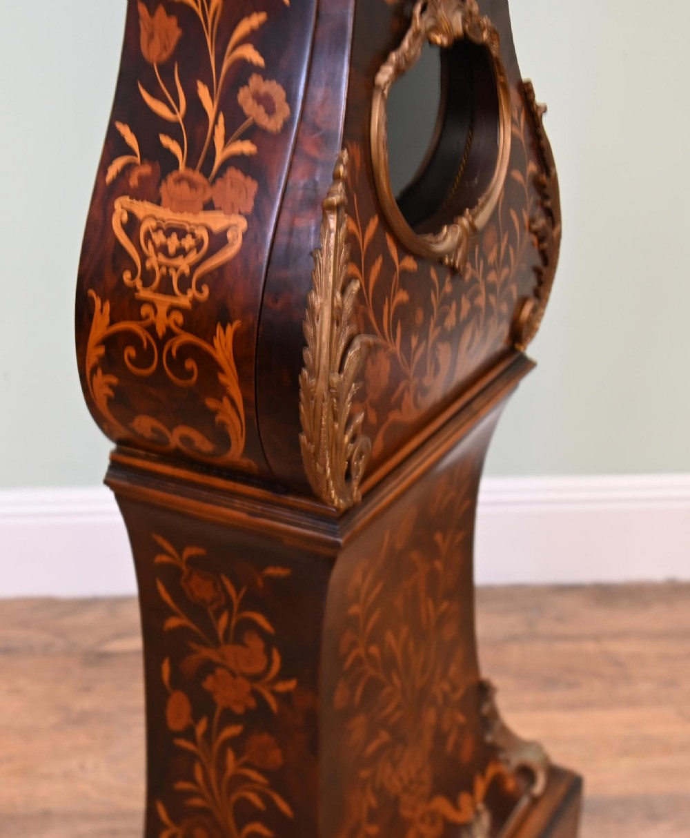 A tall French longcase clock featuring dark brown wood with elaborate floral marquetry inlay, gilt brass mounts, and a circular white enamel dial. View XI