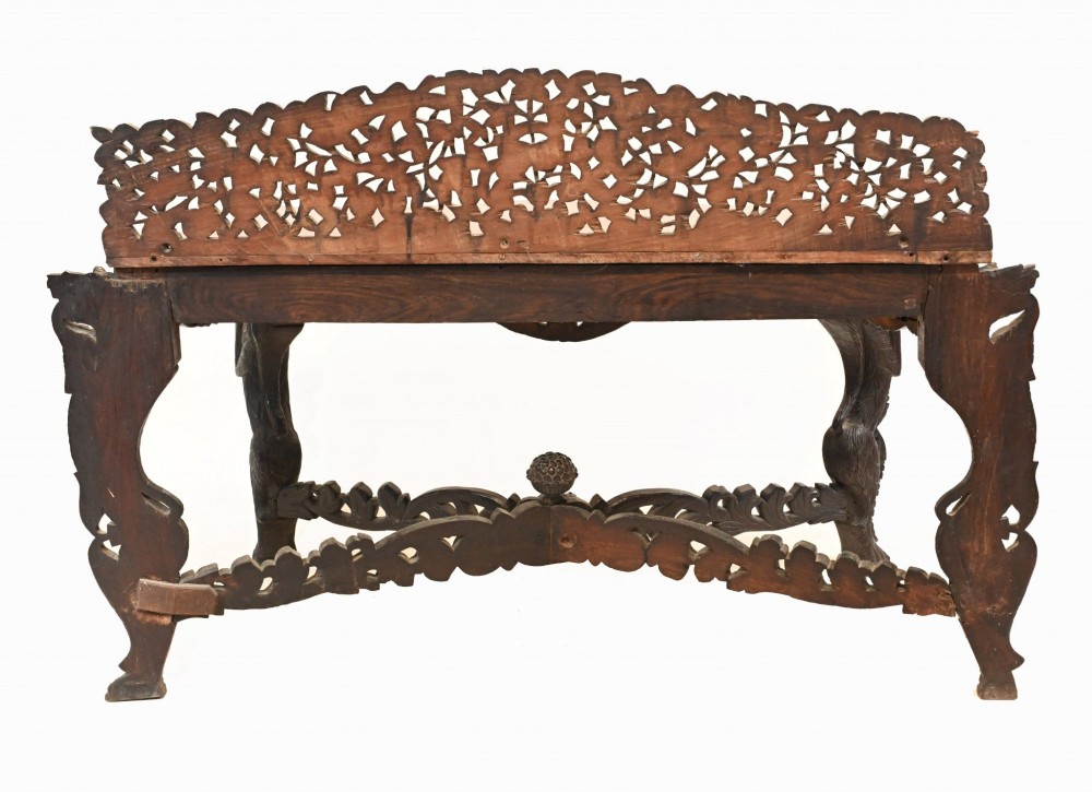 A late 19th-century Burmese dark teak console table featuring intricately pierced foliate carvings on the gallery back, skirt, and cross-stretcher, supported by legs carved as mythical figures. View IX