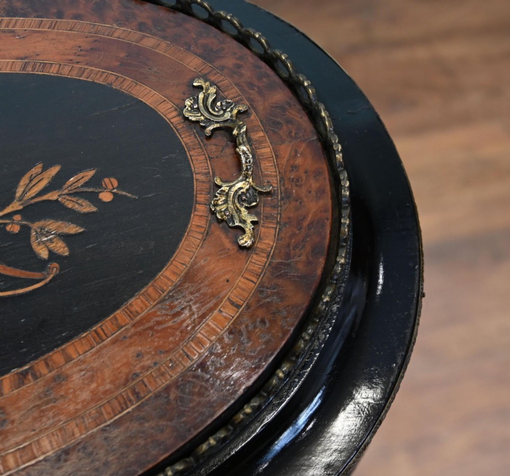 An antique French oval jardiniere table featuring amboyna wood veneer, floral marquetry, gilt-metal mounts, and ebonised cabriole legs. View III