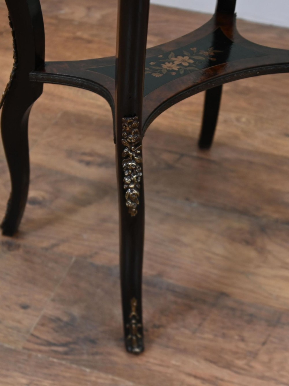 An antique French oval jardiniere table featuring amboyna wood veneer, floral marquetry, gilt-metal mounts, and ebonised cabriole legs. View IV