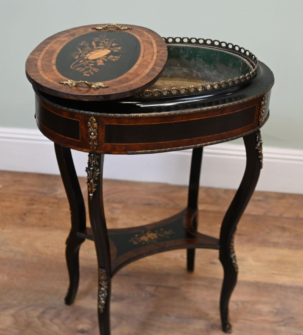 An antique French oval jardiniere table featuring amboyna wood veneer, floral marquetry, gilt-metal mounts, and ebonised cabriole legs. View V