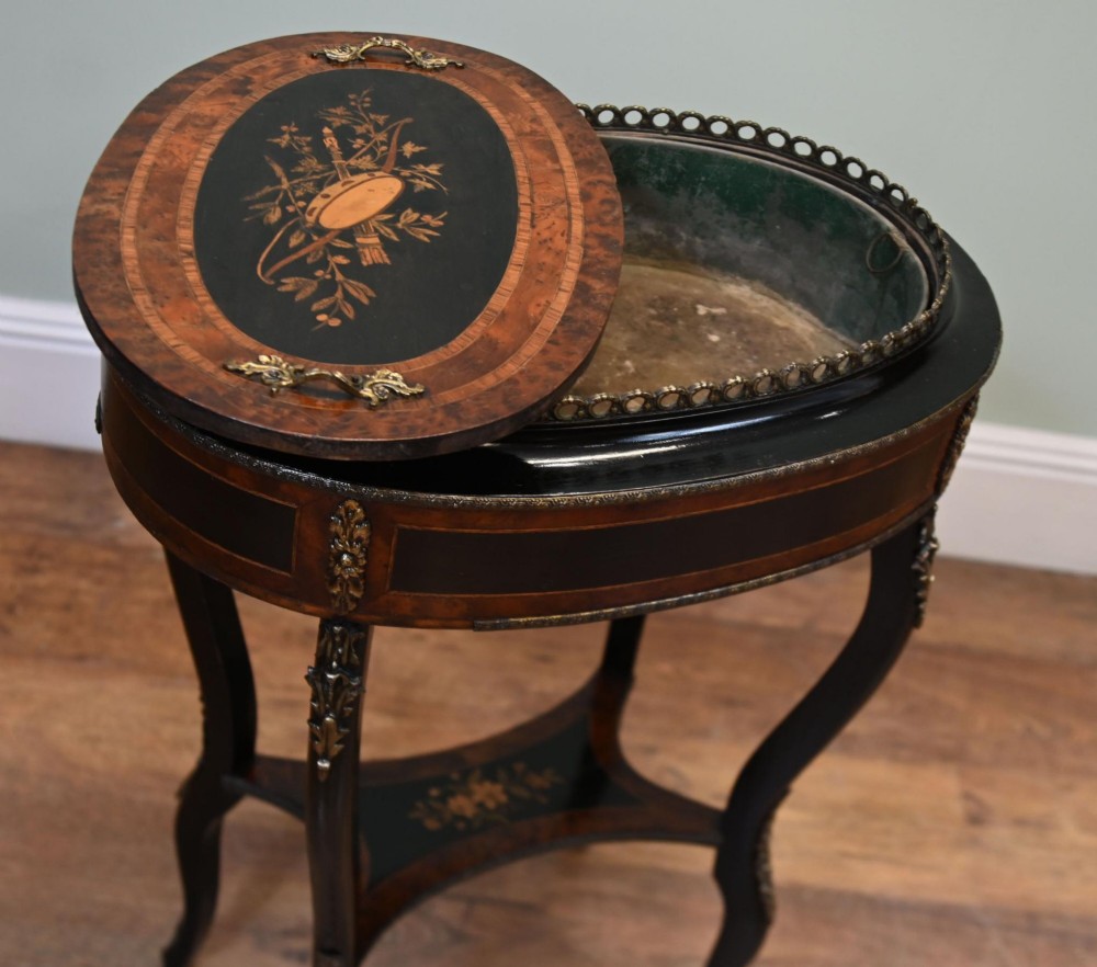 An antique French oval jardiniere table featuring amboyna wood veneer, floral marquetry, gilt-metal mounts, and ebonised cabriole legs. View VII
