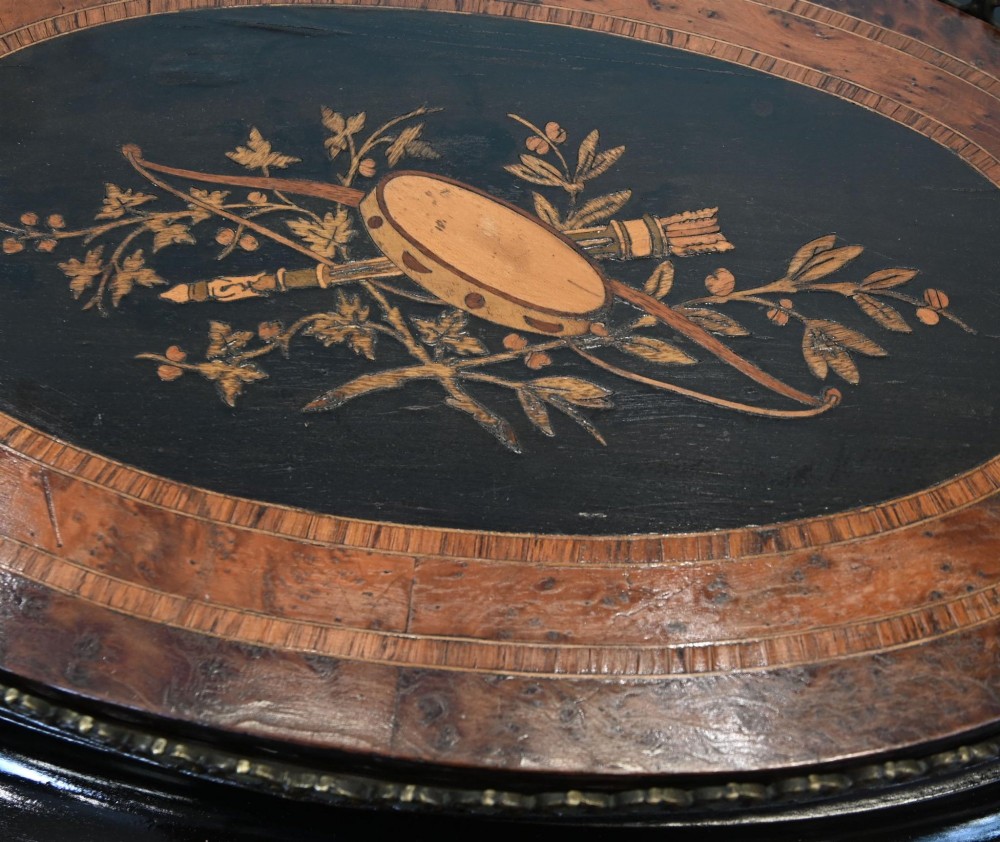 An antique French oval jardiniere table featuring amboyna wood veneer, floral marquetry, gilt-metal mounts, and ebonised cabriole legs. View IX