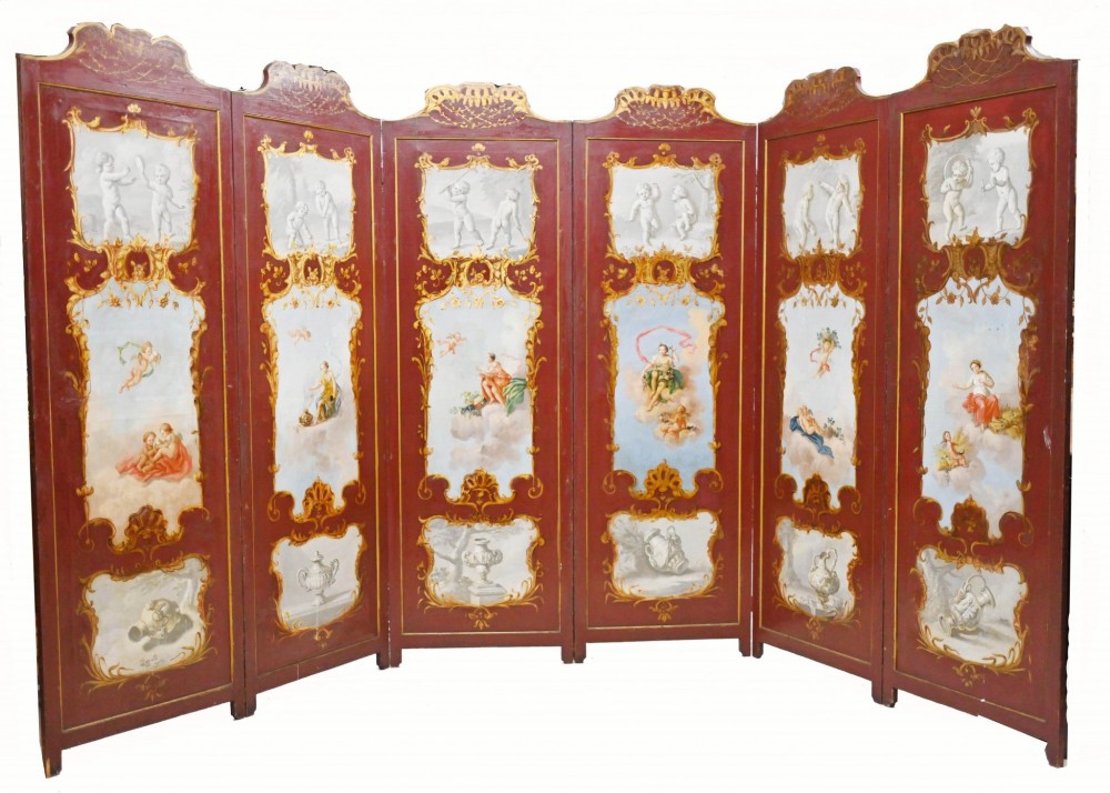 A six-panel folding room divider featuring deep red surfaces adorned with gilt rococo scrollwork frames surrounding painted classical figures, cherubs, and urns.