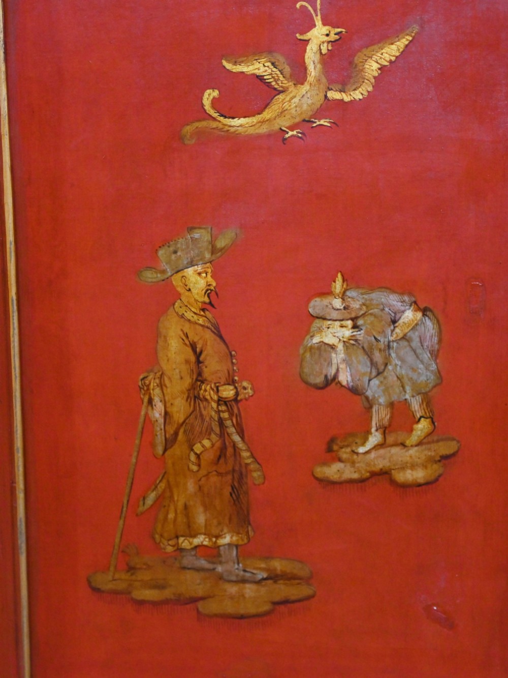 A six-panel folding room divider featuring deep red surfaces adorned with gilt rococo scrollwork frames surrounding painted classical figures, cherubs, and urns. View X