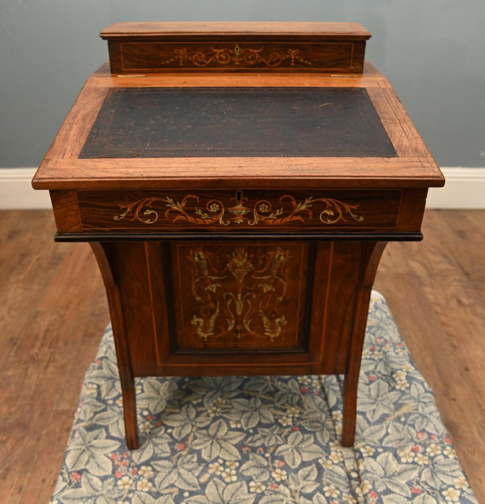 A late Victorian Sheraton Revival davenport desk crafted from warm brown wood, featuring decorative marquetry inlay and a dark leather inset writing surface. View III