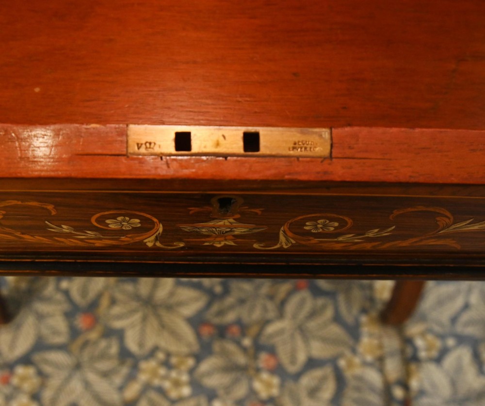 A late Victorian Sheraton Revival davenport desk crafted from warm brown wood, featuring decorative marquetry inlay and a dark leather inset writing surface. View IV