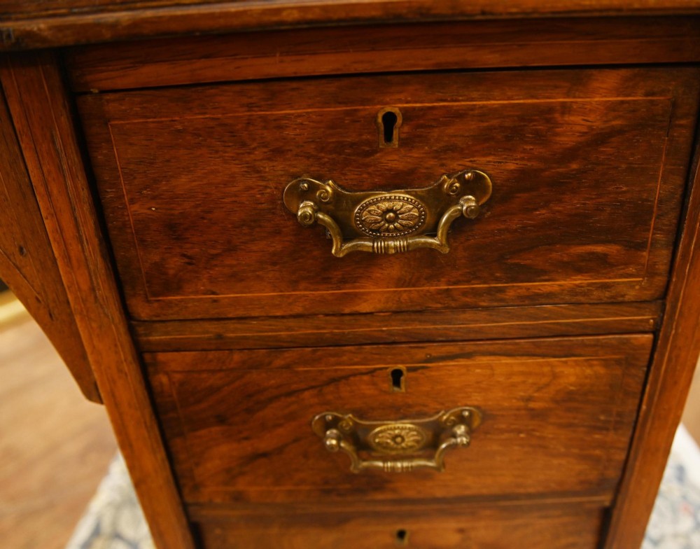 A late Victorian Sheraton Revival davenport desk crafted from warm brown wood, featuring decorative marquetry inlay and a dark leather inset writing surface. View VIII