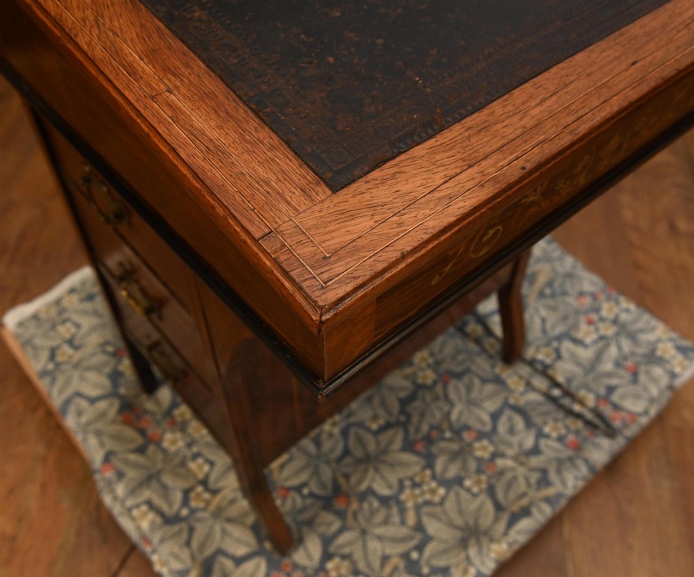 A late Victorian Sheraton Revival davenport desk crafted from warm brown wood, featuring decorative marquetry inlay and a dark leather inset writing surface. View XI