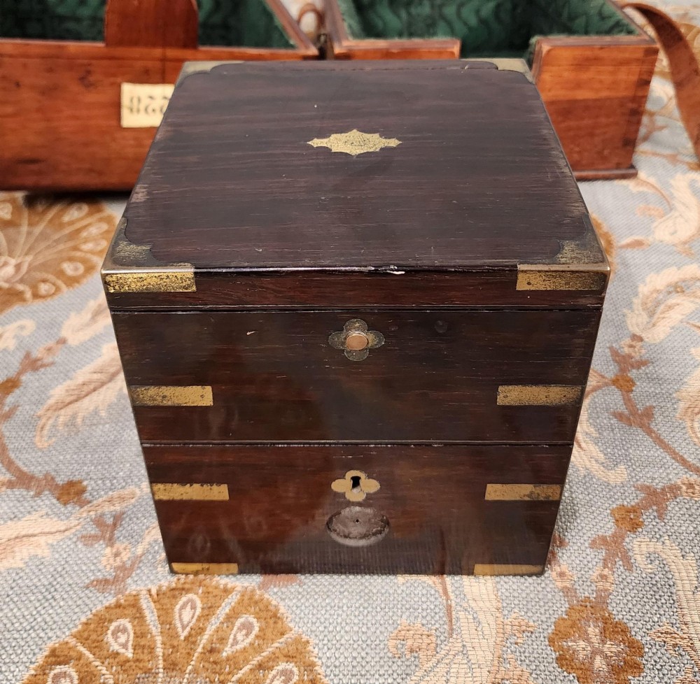 A Victorian brass marine chronometer mounted inside a brass-bound dark mahogany box with a printed manufacturer label. View IV