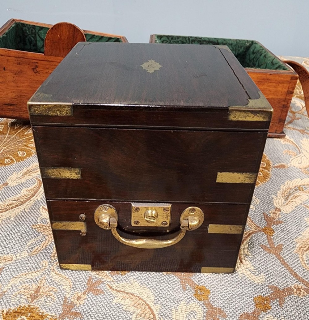 A Victorian brass marine chronometer mounted inside a brass-bound dark mahogany box with a printed manufacturer label. View V