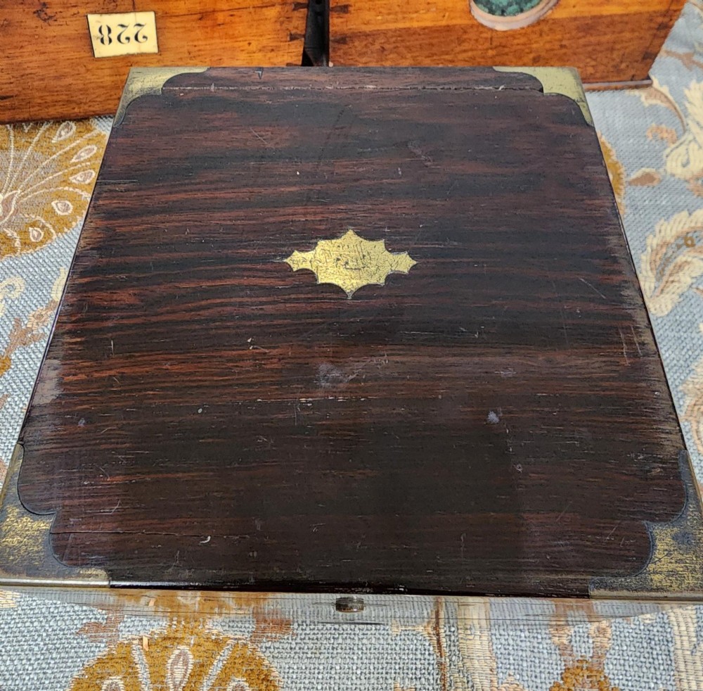 A Victorian brass marine chronometer mounted inside a brass-bound dark mahogany box with a printed manufacturer label. View VII