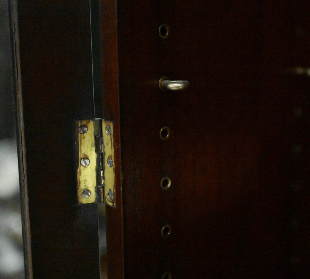 A tall Georgian mahogany glazed bookcase featuring an astragal glass upper cabinet set above four graduated drawers with brass pull knobs. View II